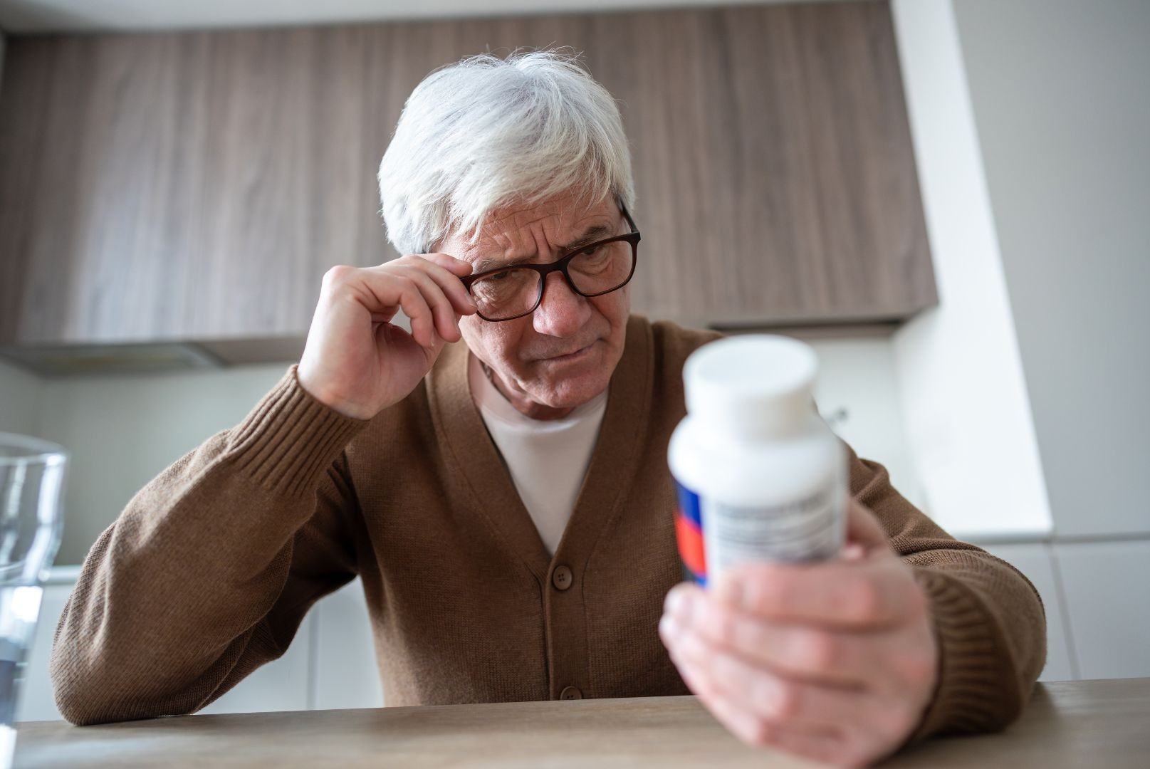 Older man looking at pill bottle - In-home Senior care