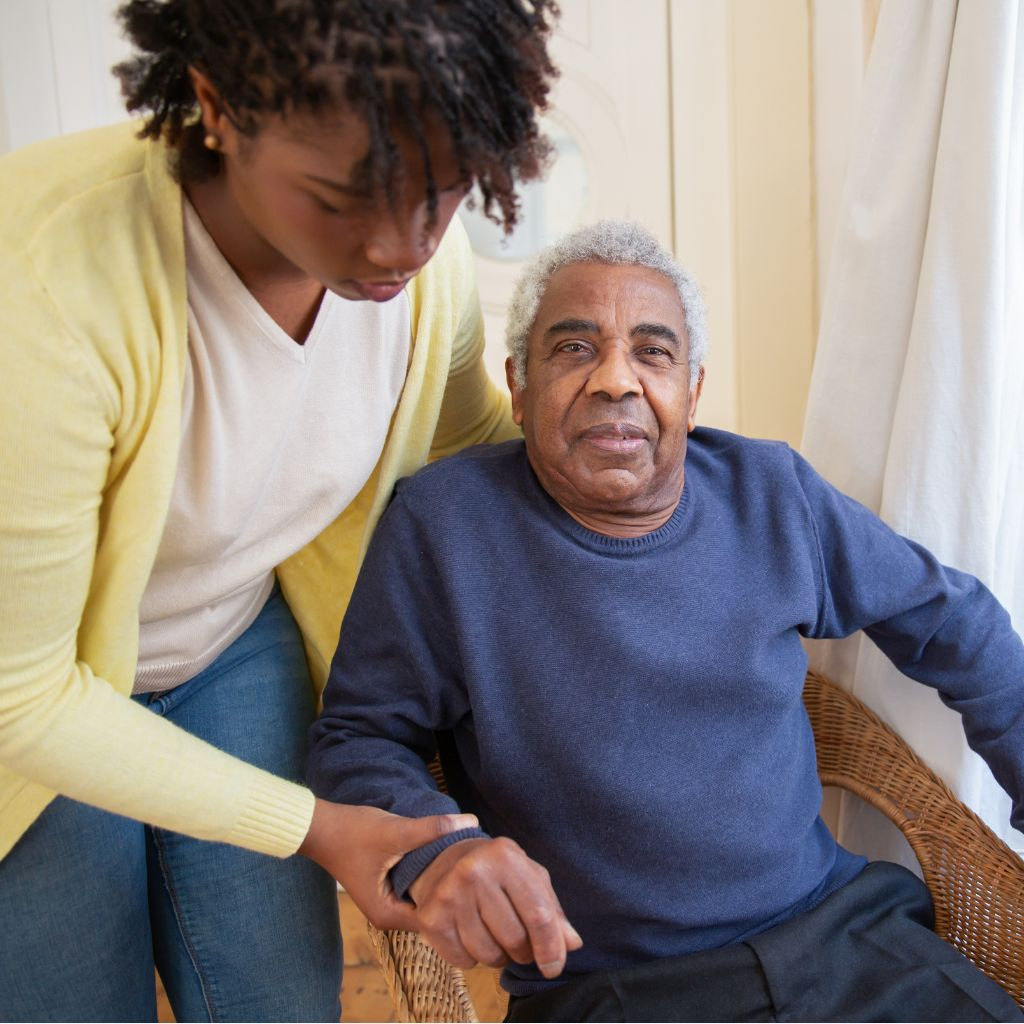 Woman helping elderly gentleman stand up